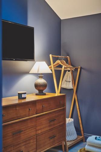 a bedroom with a dresser with a tv and a lamp at Ty Alice in Oxwich