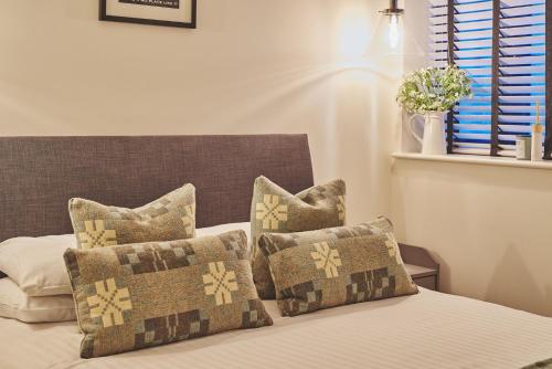 a bedroom with a bed with pillows on it at Ty Alice in Oxwich
