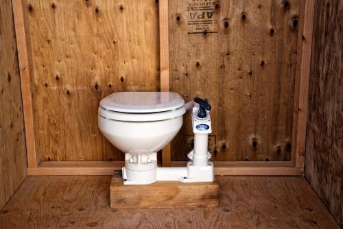 a bathroom with a toilet in a wooden wall at 28 Palms Ranch in Twentynine Palms