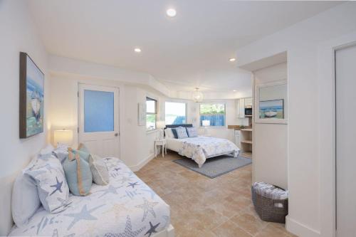 a bedroom with two beds and a living room at Oceanfront Home Retreat w Breathtaking Views of Fitzgerald Marine Reserve in Moss Beach