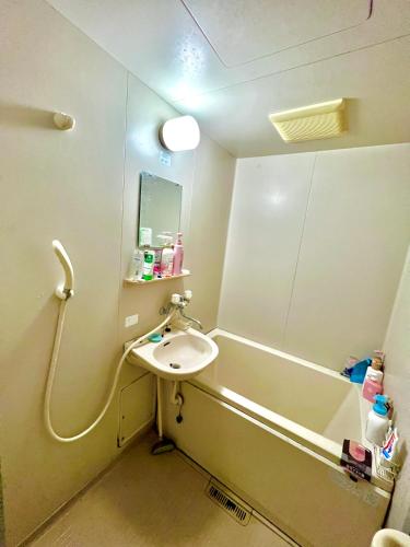 a small bathroom with a sink and a shower at Shirahama in Miyazaki