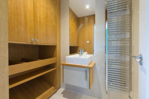a bathroom with a white sink and a shower at Secret Beach in Carbis Bay