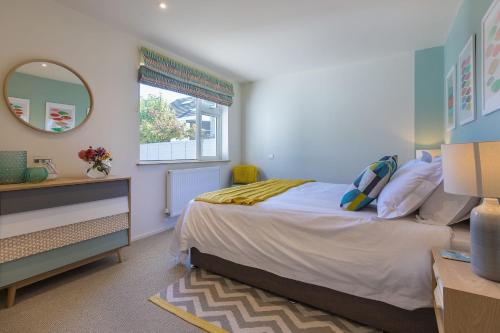 a bedroom with a bed and a mirror and a window at Secret Beach in Carbis Bay