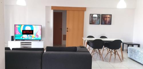 a living room with a couch and a tv and a table at ELLA LUXURY APARTMENT - (BREAKBOOKING CY) in Limassol