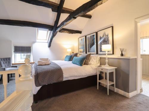 a bedroom with a large bed and a table at 3 Ivy Court in Dolgellau