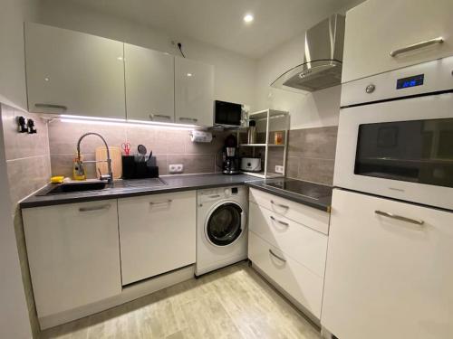 a kitchen with white cabinets and a washer and dryer at Ferienwohnung 3,5 Zimmer zentrale Lage in Duisburg