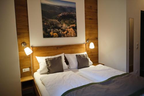 a bedroom with a bed with a painting on the wall at Wirtshaus Im Schloss Fürsteneck in Fürsteneck