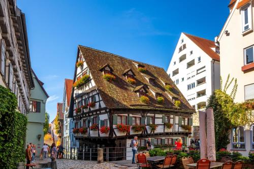 a building with a tiled roof in the middle of a street at Abbate Boutique Hotel in Ulm
