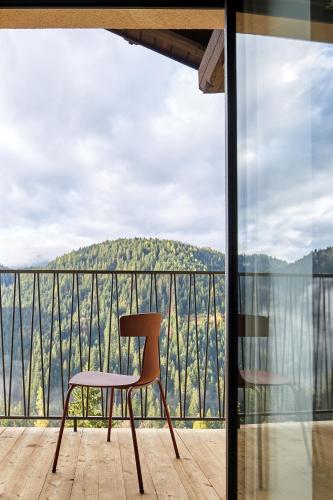 a chair sitting on a balcony with a view at Casa Lies - Apartments in Nova Ponente