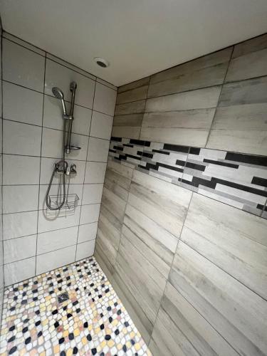 La salle de bains est pourvue d'une douche et de carrelage. dans l'établissement La Plage, à La Teste-de-Buch