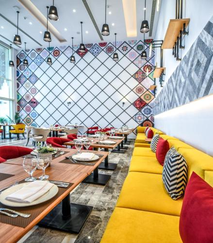 a restaurant with yellow and red chairs and tables at Tolip Resort El Galala Hills in Ain Sokhna