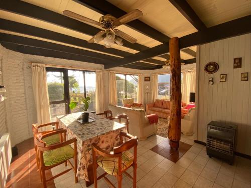 a dining room with a table and chairs and a couch at Cabañas Patagonia LicanRay in Licán Ray