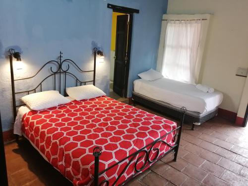 1 dormitorio con 2 camas en una habitación en Hostel Hopa Antigua, en Antigua Guatemala