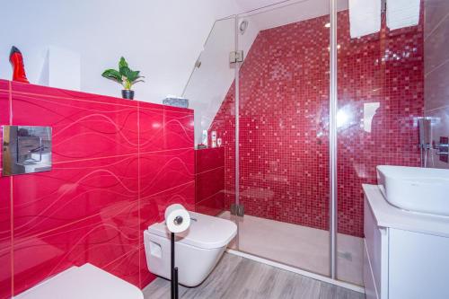 a red bathroom with a toilet and a shower at Bungalow QJ in Covilhã