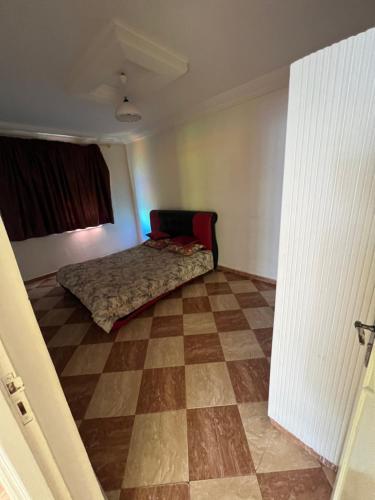 een slaapkamer met een bed en een geruite vloer bij Belle appartement 80 m2 in Marrakesh
