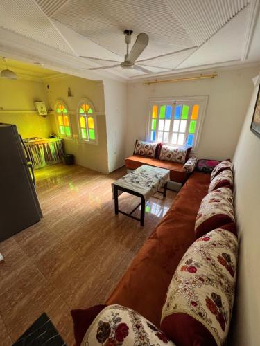 een woonkamer met een grote bank en ramen bij Belle appartement 80 m2 in Marrakesh