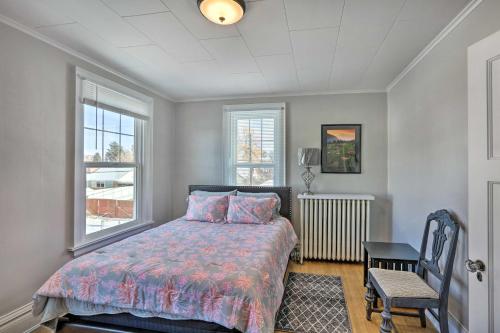 een slaapkamer met een bed, een stoel en ramen bij Cozy Dillon Apt - Near University and Fishing! in Dillon