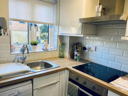 uma cozinha com um lavatório e uma janela em Cloud9StayZ at The Oakridge em Woking