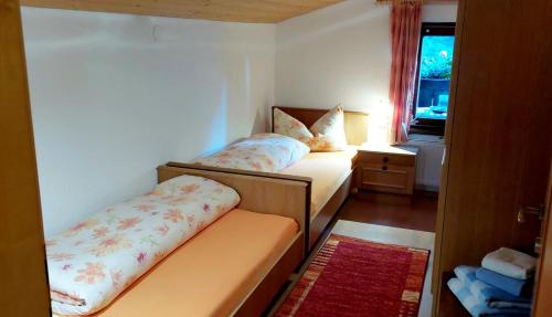 a small room with two beds and a window at Haus Greiner in Nauders