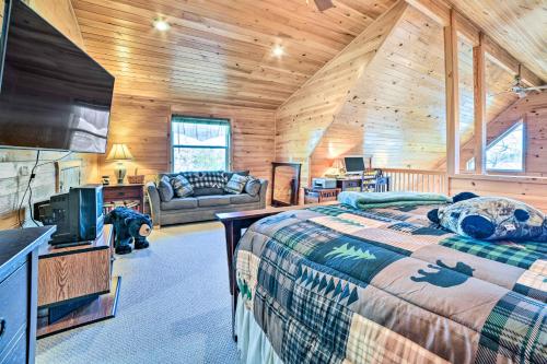 Dormitorio en cabaña de madera con cama y sofá en Secluded Lost Lake Cottage with Spacious Loft! en Hawks