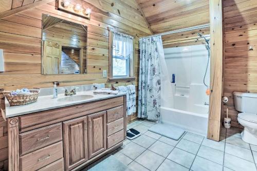 a bathroom with a sink and a toilet and a tub at Secluded Lost Lake Cottage with Spacious Loft! in Hawks