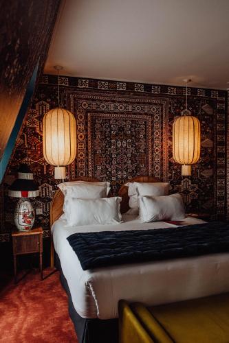 a bedroom with a large bed with a patterned wall at Hôtel Monte Cristo in Paris
