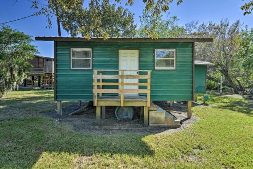 a green house with a porch in a yard at Bay Access and Dock Riverfront Tivoli Escape in Tivoli