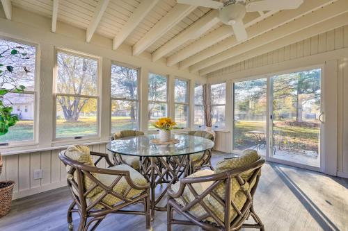 a dining room with a table and chairs and windows at Hedge House Just 4 miles to Notre Dame! in Granger