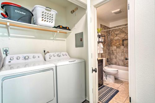 un piccolo bagno con lavatrice e servizi igienici di San Antonio Home with Hot Tub and Arcade Games! a San Antonio