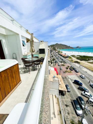 a balcony with a view of the beach at Cobertura Luxo com Jacuzzi Orla Praia Grande in Arraial do Cabo