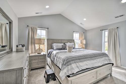 a bedroom with a bed and a dresser and windows at Bright Norfolk Home with Deck Less Than 3 Mi to Town! in Norfolk