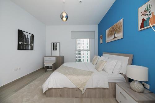 ein Schlafzimmer mit einem großen Bett mit blauer Wand in der Unterkunft Yas Island - 2 Bedrooms, 2 toilet with shared Pool & Parking in Abu Dhabi