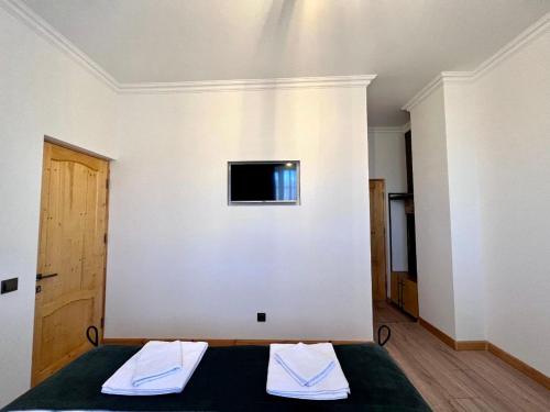 a bedroom with a bed and a tv on a wall at Sargsyan ECO house in Sevan