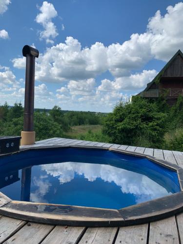 een zwembad op een houten terras met de lucht in het water bij Sidorówka nad Wigrami in Krasnopol