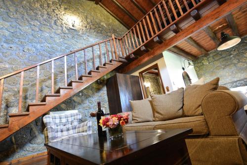 a living room with a couch and a table with flowers on it at Pera Alonia Guest House in Kato Trikala Korinthias