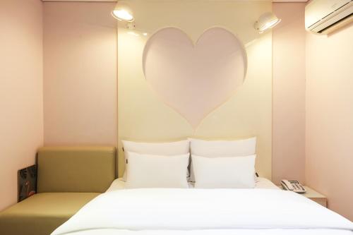 a bedroom with a heart on the wall at Laria Hotel in Suwon