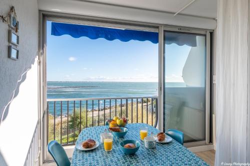 a table with fruit on it with a view of the ocean at La Plage O Maeva - Vue Mer d'exception - Parking privé - Wifi - La Grande Motte in La Grande-Motte