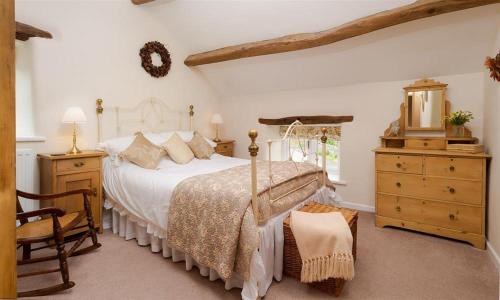 1 dormitorio con cama, silla y vestidor en Boxtree, en Penrith