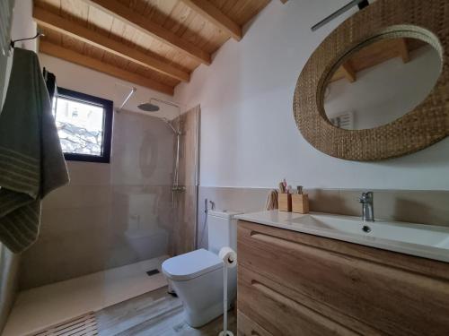een badkamer met een toilet, een wastafel en een spiegel bij villa los vaqueros in Garafía