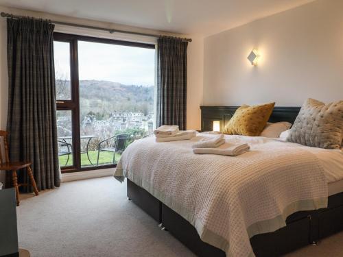 a bedroom with a bed and a large window at High Pike in Ambleside