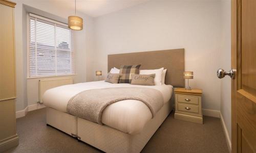 a bedroom with a large bed and a window at Hazel Cottage in Ambleside