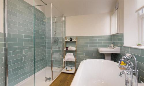 a bathroom with a bath tub and a sink at Hazel Cottage in Ambleside