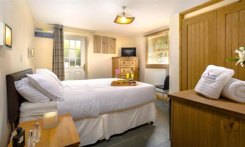 a bedroom with a large white bed and a desk at Agathi in Keswick