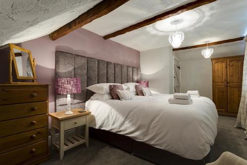 1 dormitorio con 1 cama blanca grande y vestidor en Acorn Cottage, en Grasmere