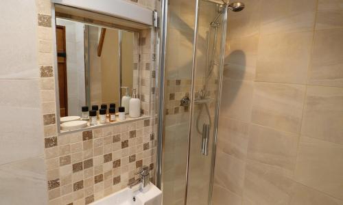 een douche met een glazen deur in de badkamer bij The Old Carriage House in Ambleside