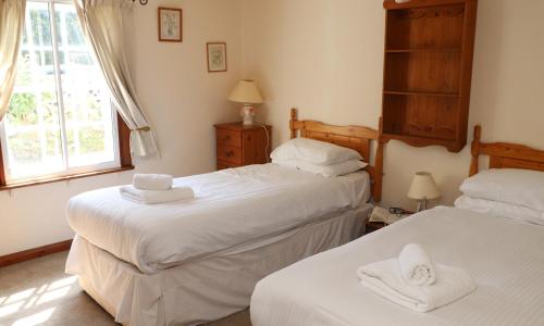 een slaapkamer met 2 bedden en handdoeken bij The Old Carriage House in Ambleside