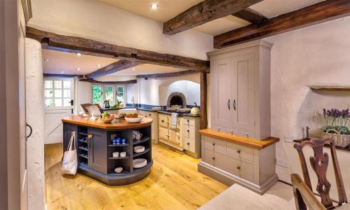 a large kitchen with an island in the middle at Fair Rigg Old Farm in Cartmel