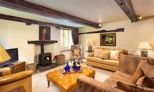a living room with a couch and a fireplace at Fair Rigg Old Farm in Cartmel