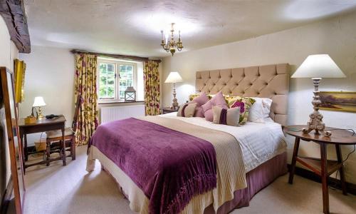 sypialnia z dużym łóżkiem i fioletowym kocem w obiekcie Fair Rigg Old Farm w mieście Cartmel