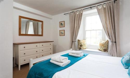 a bedroom with a bed with towels on it at Pollys Cottage in Elterwater